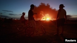 Діти споглядають пожежу на нафтопереробному заводі в штаті Фалько, Венесуела