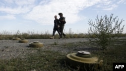Військові проходять повз протитанкові міни, встановлені на позиціях українських сил в Луганській області, серпень 2015 року