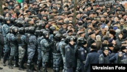Police corral demonstrators protesting against social welfare cuts in Kyiv. 