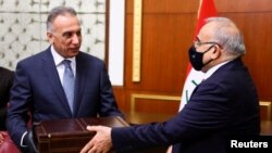 Former Iraqi Prime Minister Adel Abdul Mahdi (R) hands over to new Prime Minister Mustafa al-Kadhimi in Baghdad, Iraq, May 7, 2020