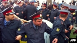 Russian police officers cordon off an area in the city of Astrakhan to block off mayoral candidate Oleg Shein and his supporters who are in the fourth week of a hunger strike against purported vote fraud.