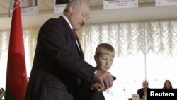 Беларус Президенти А.Лукашенка ўғли Николай билан Минскдаги сайлов участкасида овоз бермоқда, 2012 йил 23 сентябр.