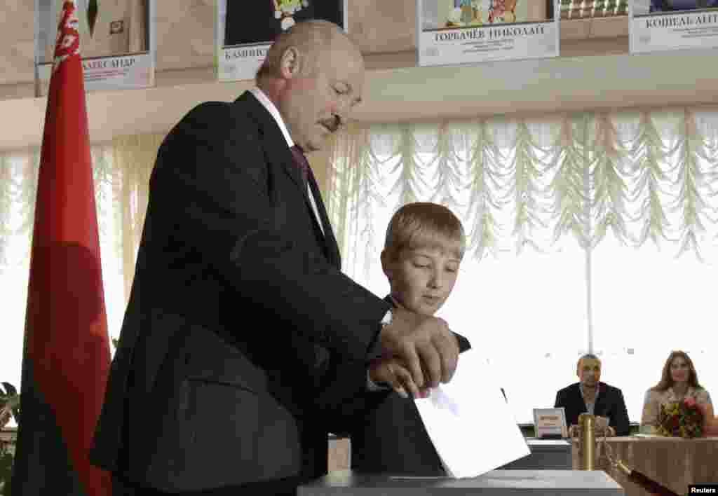 Belarusian President Alyaksandr Lukashenka, accompanied by his son Mykalay, casts his ballot at a polling station in Minsk.