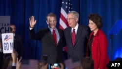 Мітч Макконел (посередині) святкує зі своєю дружиною Елейн Чао та сенатором Рендом Полом своє переобрання у сенат, 4 листопада 2014 року, Луїсвілл, штат Кентуккі