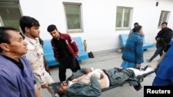 Medics carry an injured police officer to a hospital after a suicide bomb attack in Kabul on January 10.