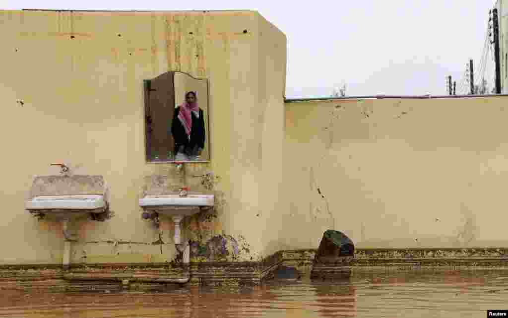 A man is reflected in a mirror in his flooded home after heavy rain in Tabuk, Saudi Arabia. (Reuters/Mohamed Alhwaity)