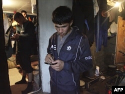 Тәжік мигранты телефонымен хабарлама жіберіп тұр. Мәскеу, 23 қыркүйек 2009 жыл.