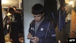 A Tajik migrant worker sends a message on his mobile phone, Moscow.