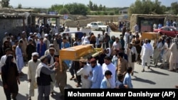 FILE: Men carry the coffin of a relative who died during Afghan forces' raid on a house in Chaparhar district of Nangarhar province in May.