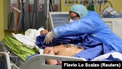 Foto nga një spital në Milano të Italisë. Një punëtore shëndetësore kujdeset për një pacient. 
