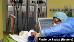 Италиялық дәрігер коронавирус жұқтырған адамды қарап жатыр. Милан, 27 наурыз 2020 жыл.