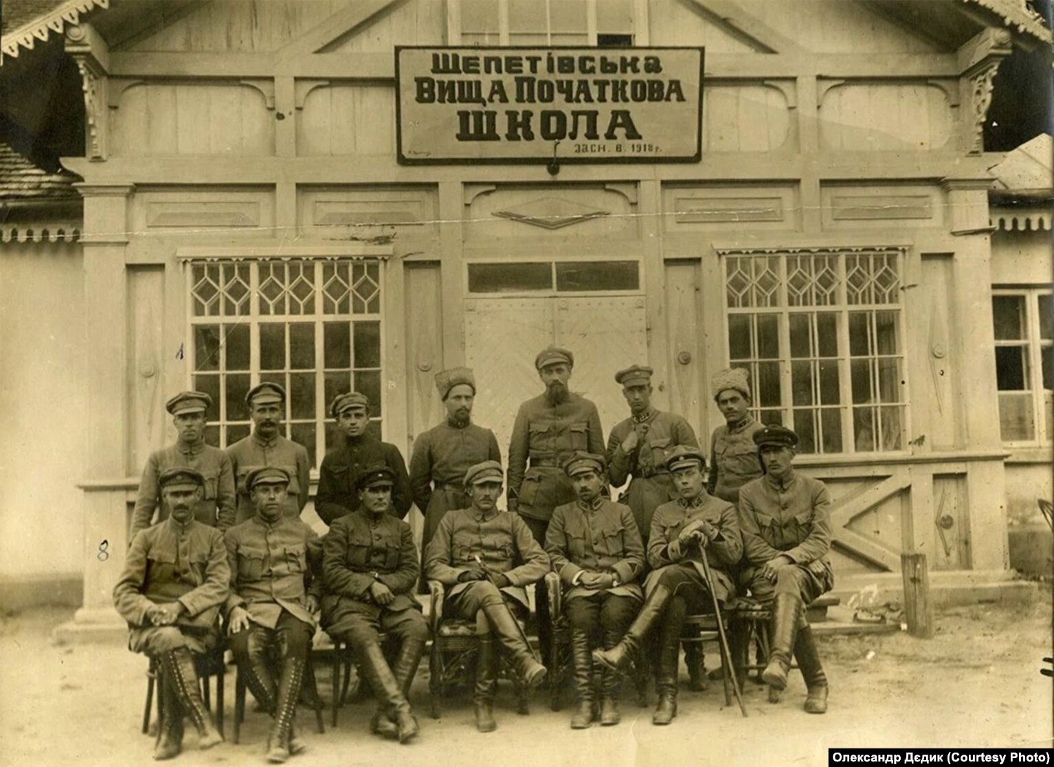 Відвідини комендантом корпусу Січових стрільців, полковником Армії УНР Євгеном Коновальцем штабу 11-ї дивізії Січових стрільців (командир Роман Сушко), Шепетівка (тепер Хмельницької області), 1919 рік. Зліва направо сидять: 2-й Михайло Матчак, далі Марко Безручко, Євген Коновалець, Юрій Отмарштейн, Роман Сушко