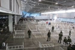 Serbian soldiers prepare beds for treatment of possible COVID-19 patients inside the Novi Sad Fair on March 27.