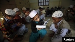 A student recites as others listen while they memorize the Koran at the Jamia Binoria Al-Alamia Seminary Islamic Study School in Karachi.