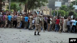Египетская армия сдерживает сторонников Мурси, чтобы не допустить столкновений с его противниками. Каир, 3 июля 2013 г. 