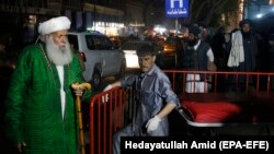 Afghan religious scholars wait outside the Emergency hospital after a suicide attack targeted a religious gathering at a wedding hall in Kabul on November 20.