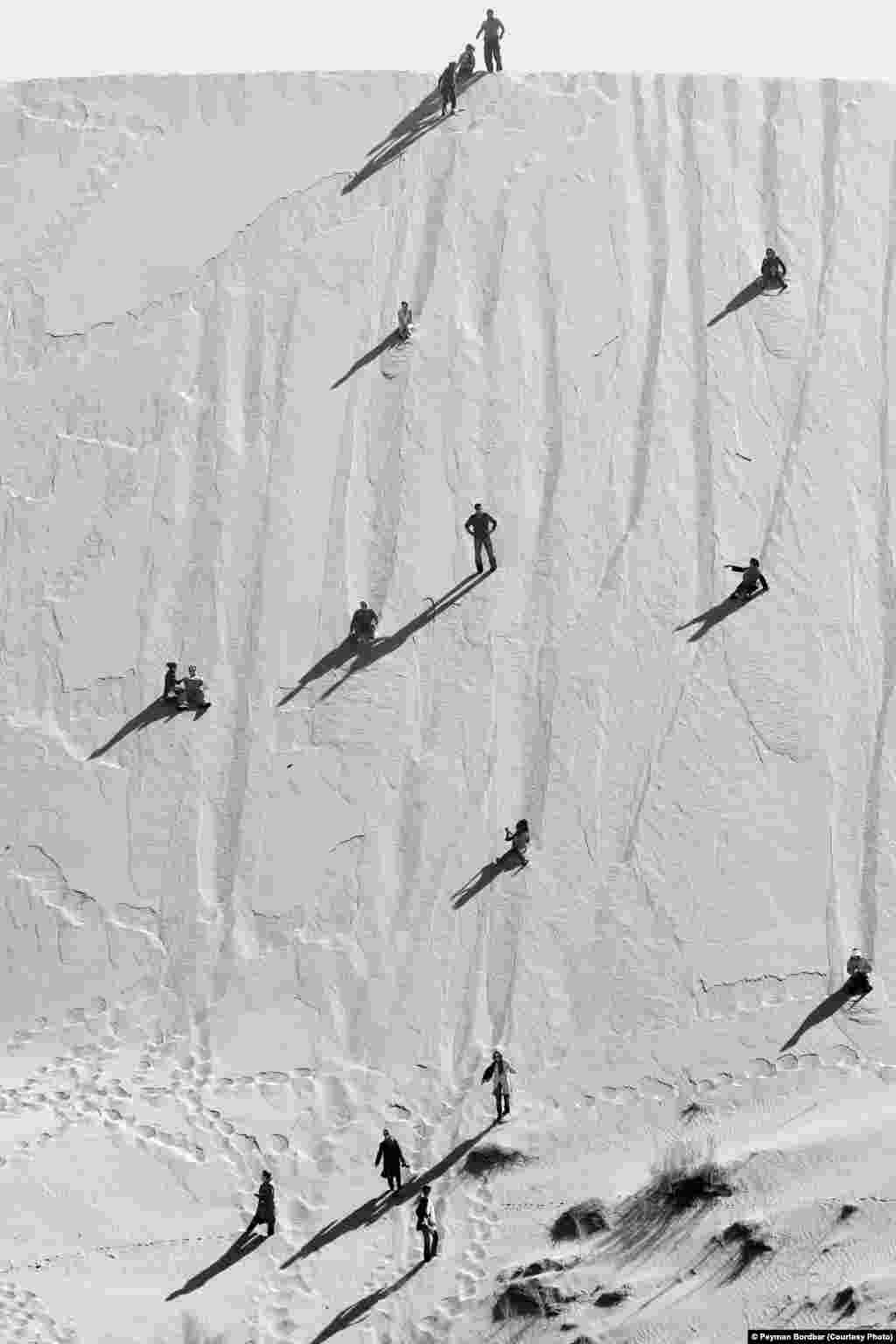 Photographer Peyman Bordbar of Iran was selected in the Travel category for this shot of people playing on dunes in Iran&#39;s desert.