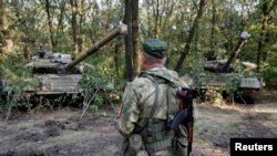 A pro-Russian separatist from the Vostok Battalion stands in front of T-64 tanks in Donetsk on July 16.