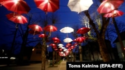 Почти безлюдная свадьба в период пандемии – под инсталляцией из зонтиков в цветах национального флага. Огре, Латвия, 5 мая 2020 года