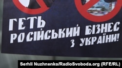 Наклейка активистов во время акции в Киеве против российского бизнеса на Украине