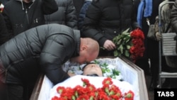 Mikhail Markelov, the brother of slain human rights lawyer Stanislav Markelov, pays his last respects at his brother's funeral in Moscow in 2009.