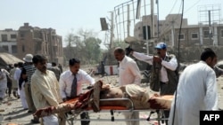 Volunteers transport an injured victim at the scene of the suicide car bomb attack in Lahore on May 27.