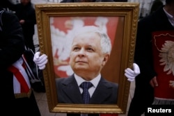 Мужчина держит фотографию Леха Качиньского во время церемонии памяти покойного президента Польши в Варшаве в феврале 2016 года