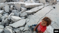 Сирийский ребенок на развалинах города