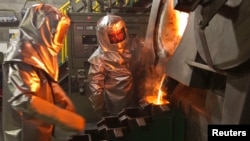 Workers pour molten gold from a crucible into moulds in a workshop at Kyrgyzstan's Kumtor gold mine. (file photo)