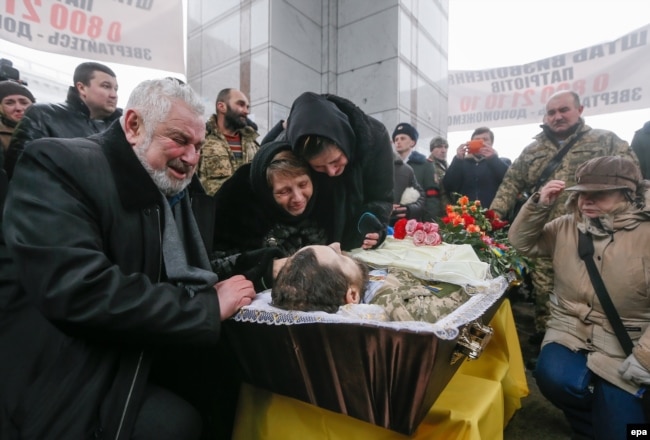 Relatives and friends react during the funeral ceremony in Kyiv for Ukrainian soldier Leonid Dergach, who was killed in renewed fighting near Avdiyivka in eastern Ukraine in early February.