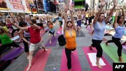 Participanţi la o sesiune practică yoga, Times Square, New York.