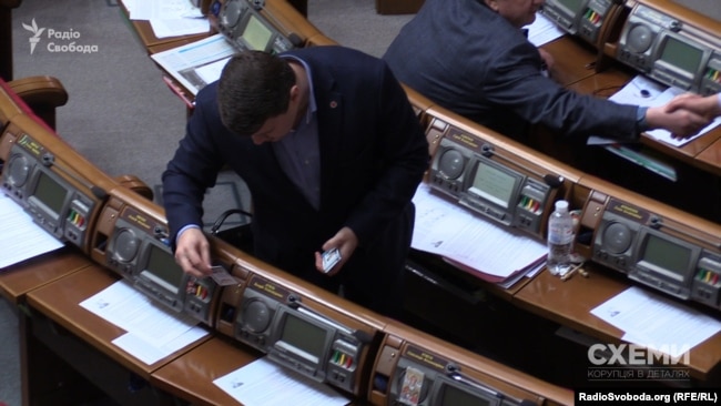 Депутат Вадим Івченко розкладає картки за депутатів фракції «Батьківщина»