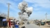 Smoke billows from the scene of a suicide bomb blast that targeted the police headquarters in the northeastern city of Kunduz in February.