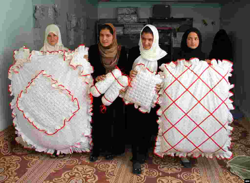 Afghan girls suffering from hearing and speech impairment display the final products after they learned to sew clothing at a center supported by the Swedish Embassy in Ghazni. (epa/Naweed Haqjoo)