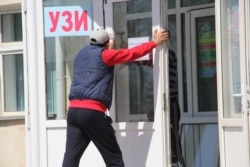 Аурухана алдында жүрген жұмысшы. Көрнекі сурет.