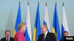 Ukraine's Yulia Tymoschenko (left) and Russia's Vladimir Putin seal the deal in Moscow.