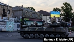 Ukrainian soldiers ride through a street in Pokrovsk, Donetsk region, on July 8.