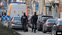Armed Belgian police patrol near the scene of an apparent operation against terror suspects in Brussels, Belgium, on March 25.