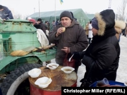Avdiyivka residents eat and warm themselves at a humanitarian-aid station.