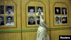 The mother of Uzair, an Army Public School victim, touches his picture in a gallery of the victims at a ceremony on the anniversary of the Taliban attack on an army school in Peshawar, December 16.