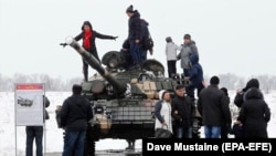 Mještani poziraju na tenku T-72 separatističkih snaga tokom proslave Dana branioca otadžbine na bivšem aerodromu u Lugansku u februaru 2020.
