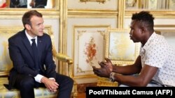 Președintele Emmanuel Macron discutînd cu Mamoudou Gassama la o întrevedere la Paris astăzi