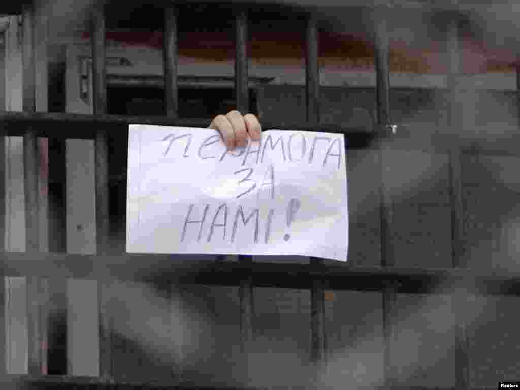 Një bjellorus tregon një letër nga dritarja e burgut në Minsk, ku shkruan "Fitorja është me ne"... 