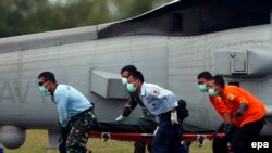 Ekipet e shpëtimit duke e bartur një trup të pajetë nga aeroplani i rrëzuar