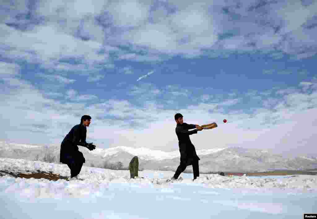 Afghan men play cricket on a field covered in snow on the outskirts of Kabul (Reuters/Mohammad Ismail)