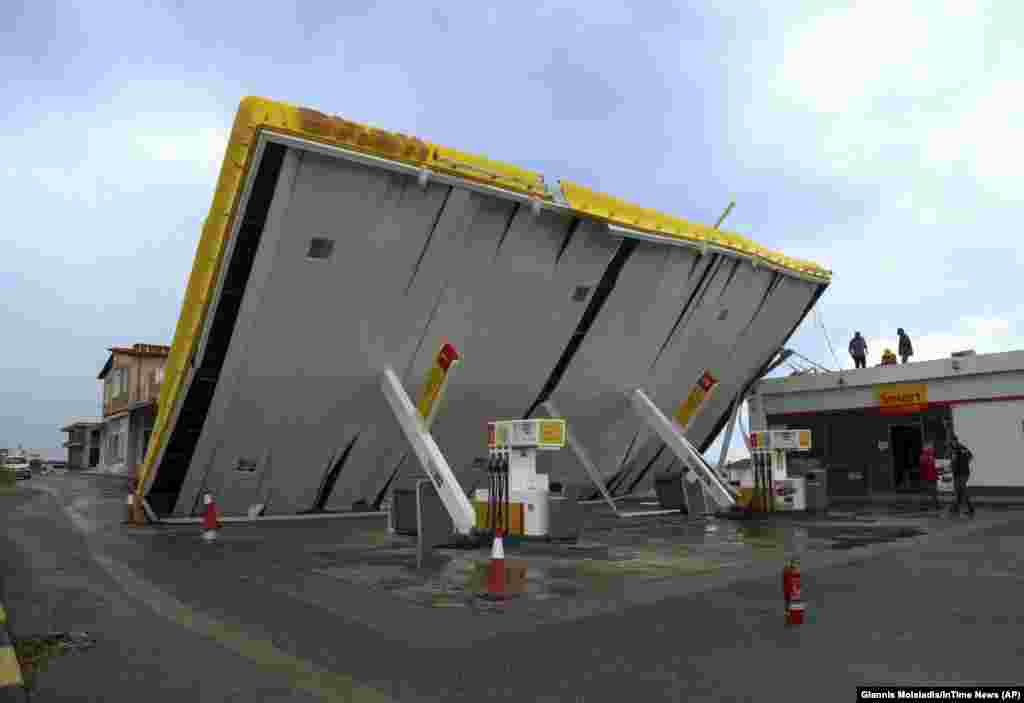 Workers check the damage at a gas station after a storm in the Halkidiki region of northern Greece. (AP/Giannis Moisiadis)