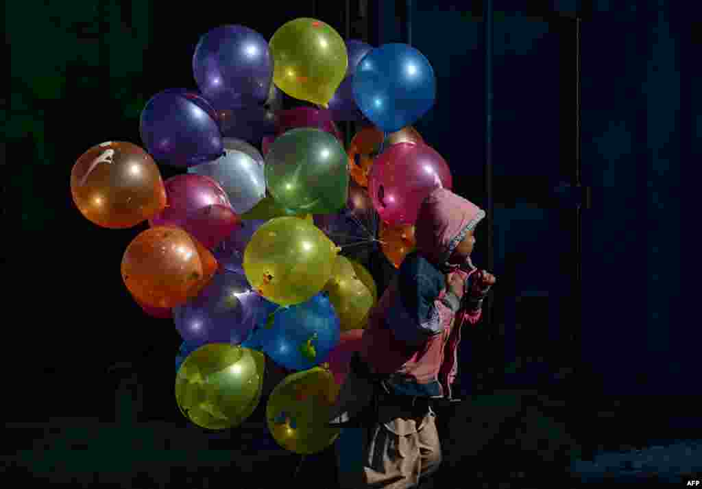 An Afghan boy walks with balloons for sale on a cold winter&#39;s day in Kabul. (AFP/Shah Marai)