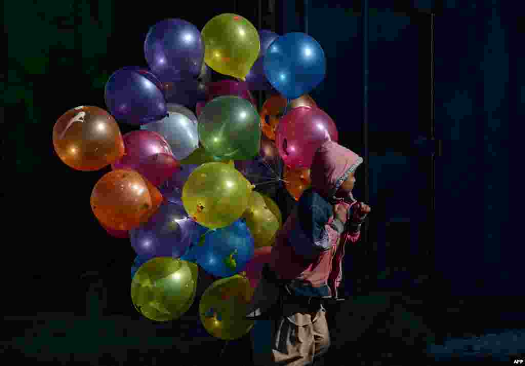 An Afghan boy walks with balloons for sale on a cold winter's day in Kabul. (AFP/Shah Marai)