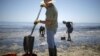 Voluntari curăță de petrol o plajă din California
