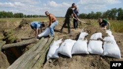 Жителі Маріуполя допомагають українським війсьвослужбовцям рити окопи і робити укріплення мішками з піском, 29 серпня 2014 року